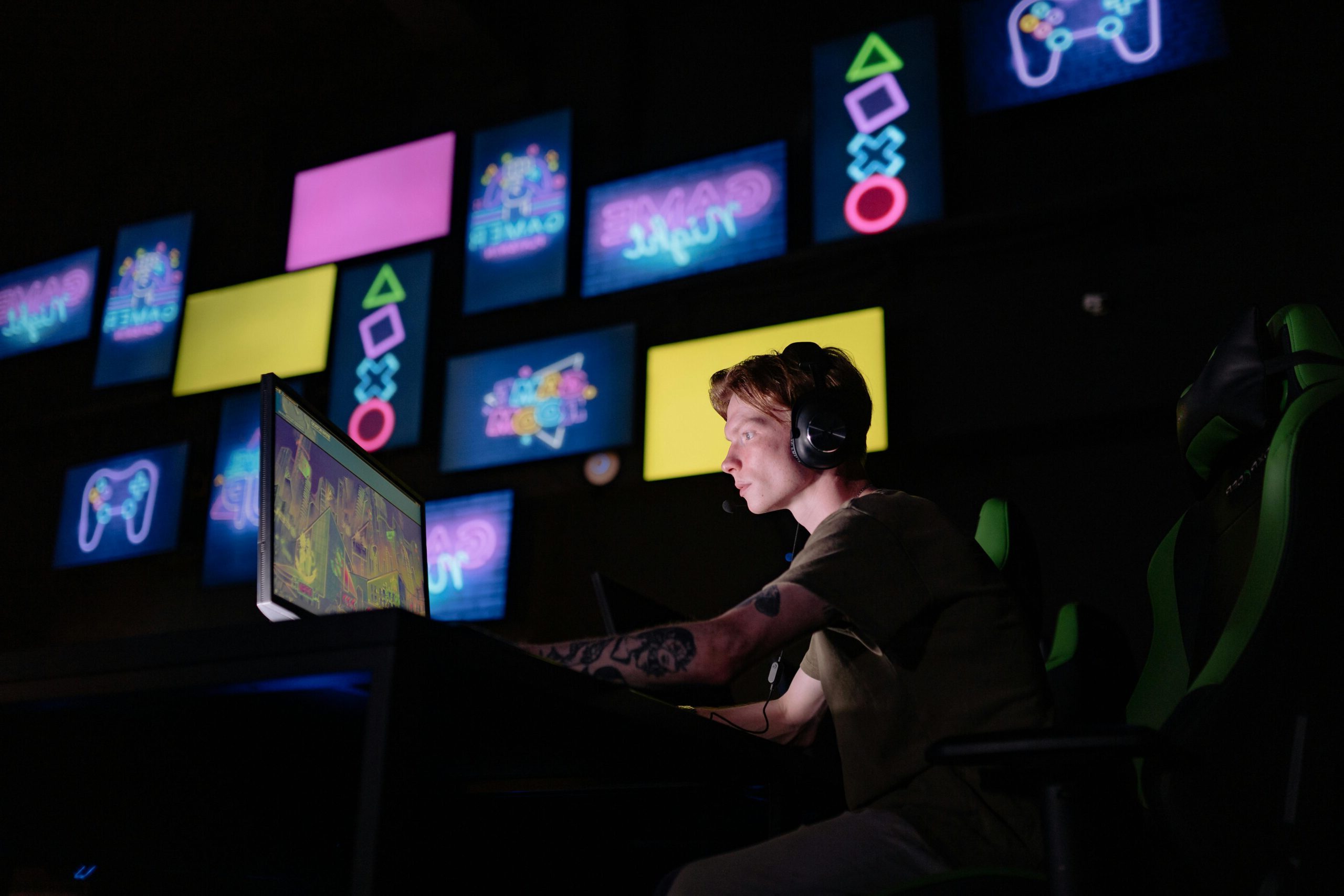 A focused gamer plays e-sports in a neon-lit room, surrounded by digital screens.
